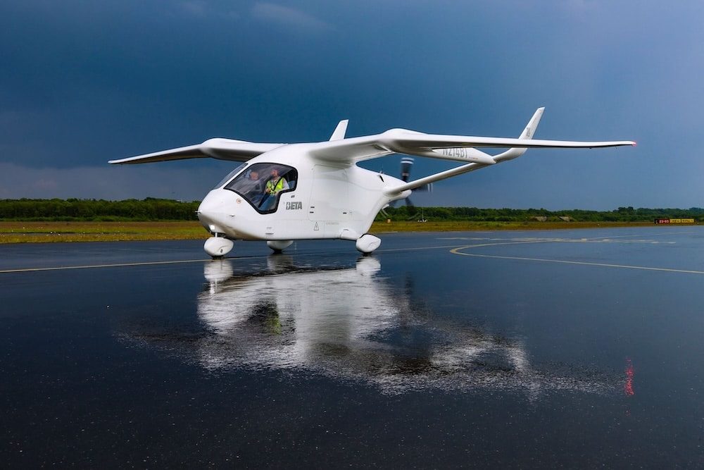 BETA ALIA up close on a wet runway, crew in the cockpit